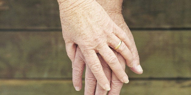 Elderly couple holding hands, close-up