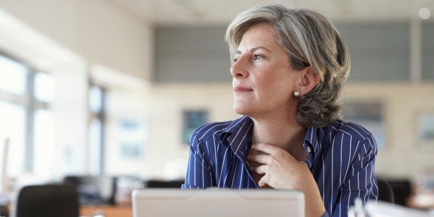 Mature businesswoman by laptop in office