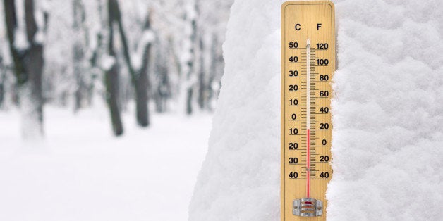 thermometer in the snow with temperature below zero degree Celsius