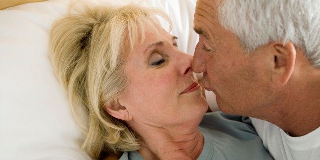 close-up of mature couple kissing in bed