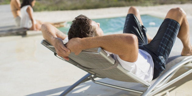 Man relaxing in lounge chair at poolside