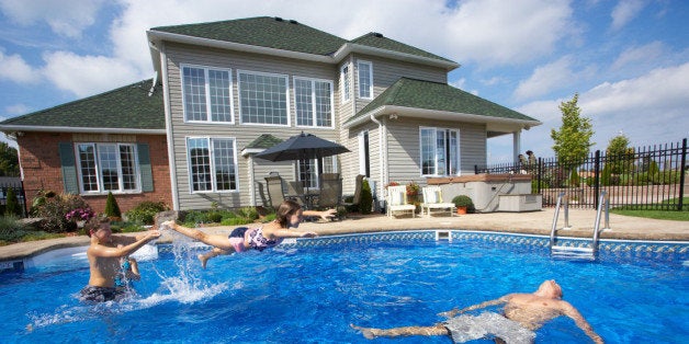 Family playing in backyard pool