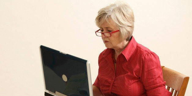 older lady on the wooden chair with the laptop