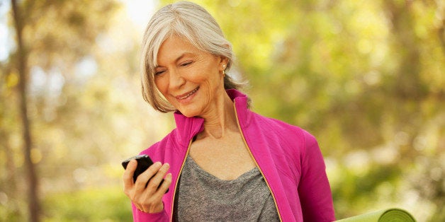 Older woman using cell phone outdoors