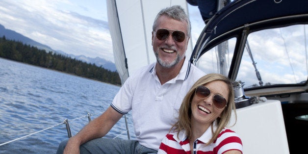 Smiling couple sitting together on a sailboat