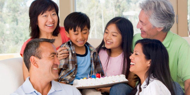 Family in living room with cake smiling