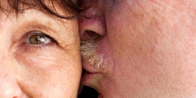 Older man kissing his wife on the cheek