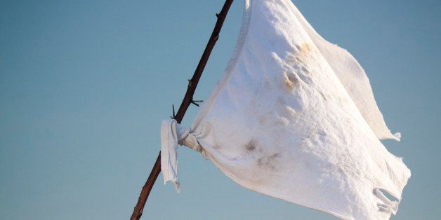 Arm holding white flag on the battlefield
