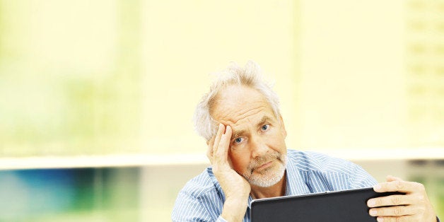 Senior, behind a laptop with a stressed expression