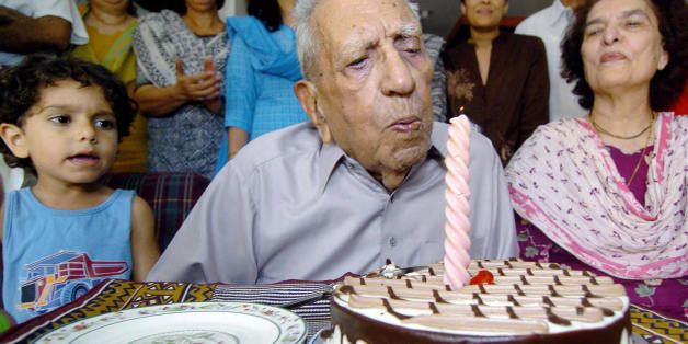LAHORE, PAKISTAN: (FILES) This file picture dated 09 September 2004 shows then world's oldest-known living Olympic medal winner Pakistani Feroze Khan (C) blowing out the candle on a cake while celebrating his 100th birthday with family members in Lahore. World's oldest Olympic medal winner Khan, who won a field hockey gold medal with the pre-partition India team in the 1928 Amsterdam Olympics, passed away peacefully late 20 April 2005, ending a great chapter of field hockey, family sources said. AFP PHOTO/Arif ALI/FILES (Photo credit should read ARIF ALI/AFP/Getty Images)