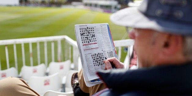 CHELMSFORD, ENGLAND - APRIL 14: A spectator does a crossword puzzle whilst watch play on day two of the LV County Championshi