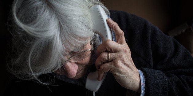 BRISTOL, ENGLAND - FEBRUARY 16: In this photo illustration an elderly person uses a telephone on February 16, 2015 near Bris