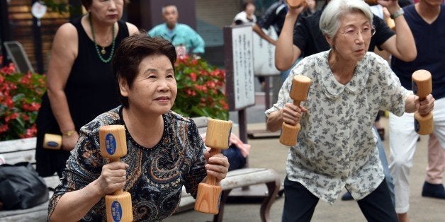 Elderly residents work out with wooden dumb-bells in the grounds of a temple in Tokyo on September 15, 2014 to celebrate Japan's Respect-for-the-Aged-Day. The number of people aged 65 or older in Japan is at a record 32.96 million, accounting for an all-time high of 25.9 percent of the nation's total population, the government announced. AFP PHOTO / Yoshikazu TSUNO (Photo credit should read YOSHIKAZU TSUNO/AFP/Getty Images)