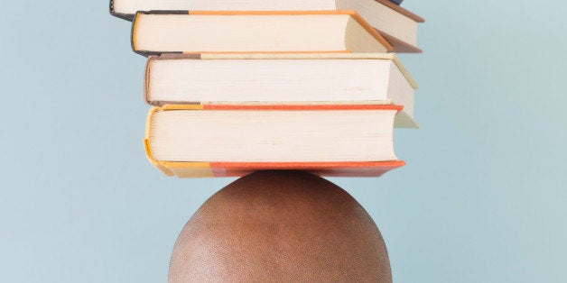 Studio shot of man with stack of books on head