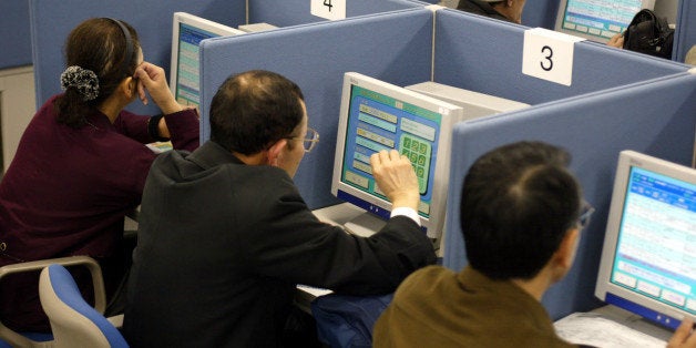 403080 01: Job seekers search for employment on computer terminals at the Hellowork employment agency March 29, 2002 in Tokyo