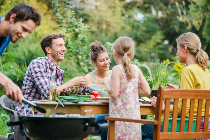 Patchwork family at barbeque event in green garden