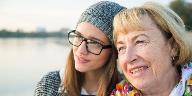 Portrait of senior woman head to head with her adult granddaughter