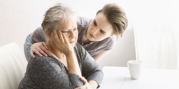 young woman consoling depressed senior woman