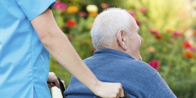 Doctor pushing old disabled patient is wheelchair.