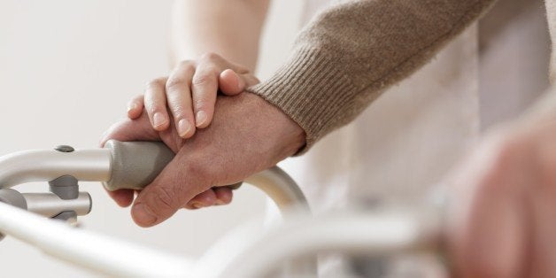 Close-up of physiotherapist supporting disabled senior man