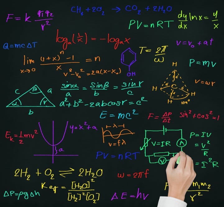 teacher hand writing high school maths and science formula on blackboard