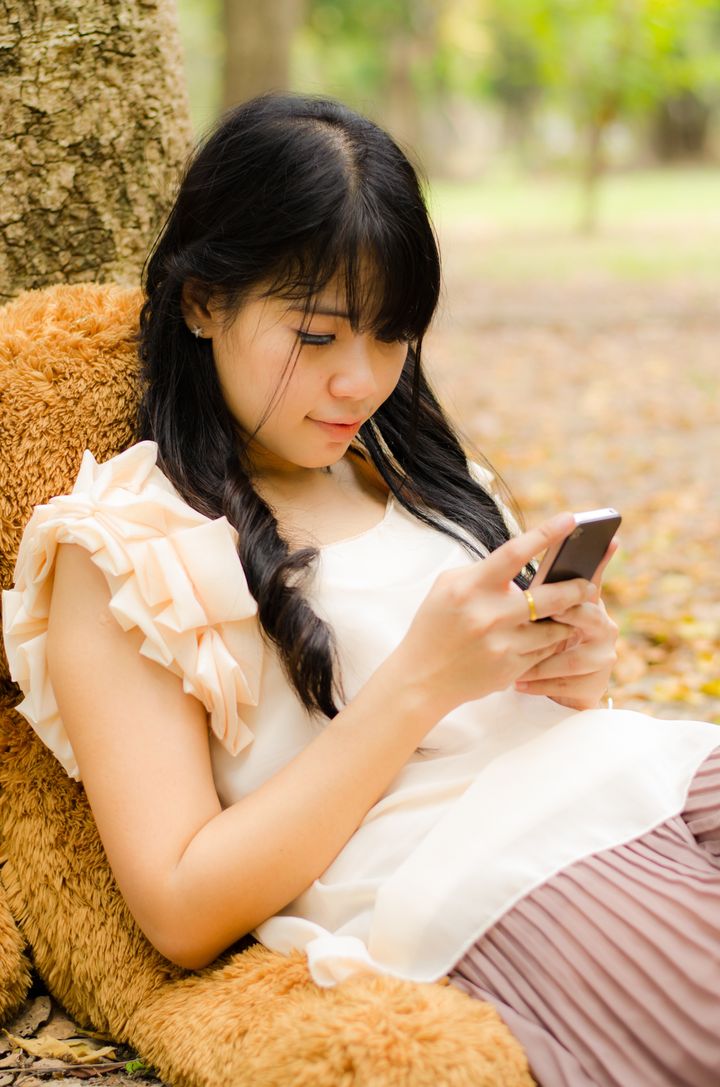 asian girl playing cell phone...