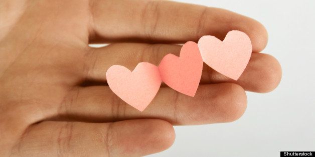 human holding little paper cutout hearts, love concept