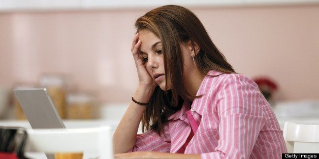 Stressed teenage girl with laptop computer