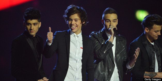 Harry Styles (2L) gives a thumbs-up as he and his bandmates Zayn Malik, Liam Payne, Louis Tomlinson, and Niall Horan of British-Irish pop band One Direction celerbate accept the Global Sucess award during the BRIT Awards 2013 ceremony in London on February 20, 2013. AFP PHOTO / BEN STANSALL (Photo credit should read BEN STANSALL/AFP/Getty Images)