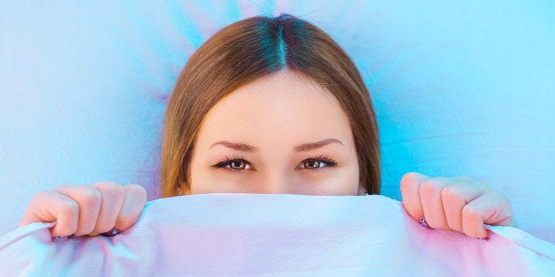 shy girl in bed smiling