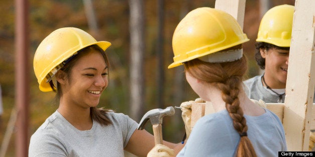 Volunteers wearing hard-hats working at construction site