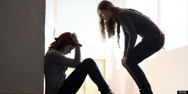 Teen girl offers to help her friend crying on the floor. silhouette