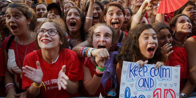 MADRID, SPAIN - AUGUST 20: Fans react as they attend the ''One Direction This Is Us' premiere red carpet London Connection From Madrid' on a giant plasma tv displayed on the front of Callao Cinema on August 20, 2013 in Madrid, Spain. (Photo by Gonzalo Arroyo Moreno/Getty Images)