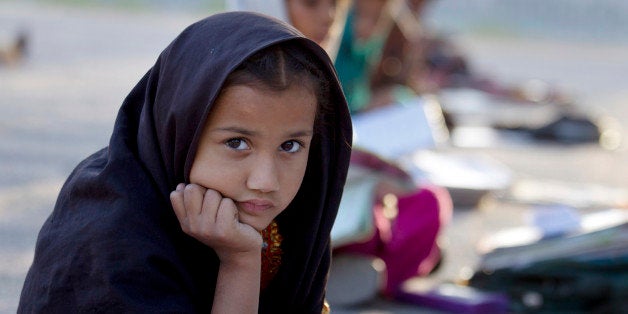 Pakistani student Farah Muneeb from Islamabad's slums sits with fellow students at a makeshift school set up by a volunteer in a park in Islamabad, Pakistan, Thursday, Oct 11, 2012. The United Nations has declared October 11 as the International Day of the Girl Child. Girls face double discrimination due to their gender and age, and are the most marginalized and discriminated group across the globe. (AP Photo/B.K. Bangash)