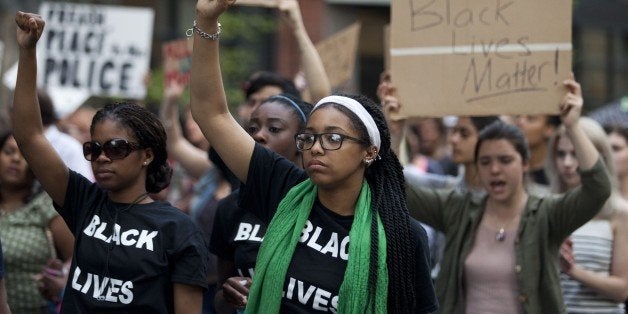 Protesters raise their fists during a march trough Baltimore, Maryland on April 29, 2015. Thousands of young protesters marc