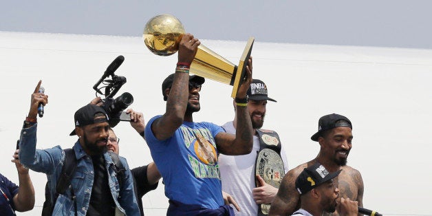 Cleveland Cavaliers' LeBron James holds up the NBA Championship trophy alongside teammates after arriving in Cleveland, Monda
