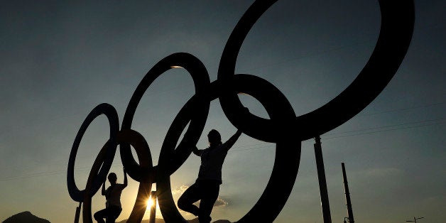 People pose for a photo with the Olympic Rings at the Olympic Park in Rio de Janeiro, Brazil, Monday, Aug. 1, 2016. The Summer 2016 Olympics is scheduled to open Aug. 5. (AP Photo/Charlie Riedel)