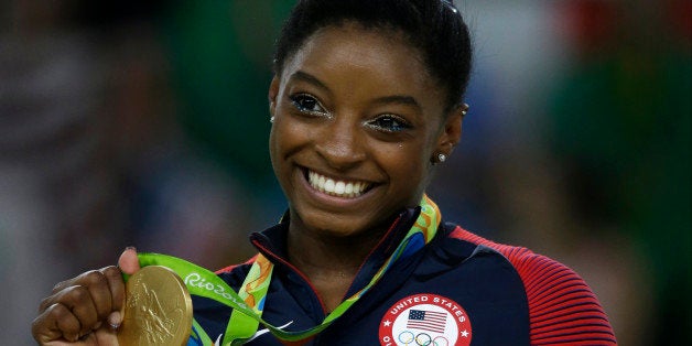 United States' Simone Biles displays her gold medal for floor during the artistic gymnastics women's apparatus final at the 2