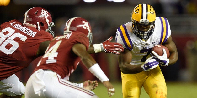 Nov 7, 2015; Tuscaloosa, AL, USA; LSU Tigers running back Leonard Fournette (7) runs the ball while defended by Alabama Crimson Tide defensive lineman A'Shawn Robinson (86) and defensive back Geno Matias-Smith (24) during the second quarter at Bryant-Denny Stadium. Mandatory Credit: John David Mercer-USA TODAY Sports