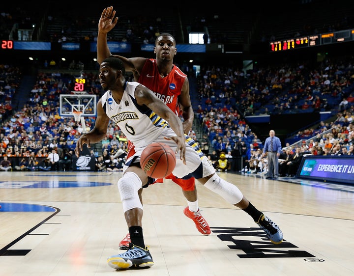 LEXINGTON, KY - MARCH 21: Jamil Wilson #0 of the Marquette Golden Eagles drives against De'Mon Brooks #24 of the Davidson Wil