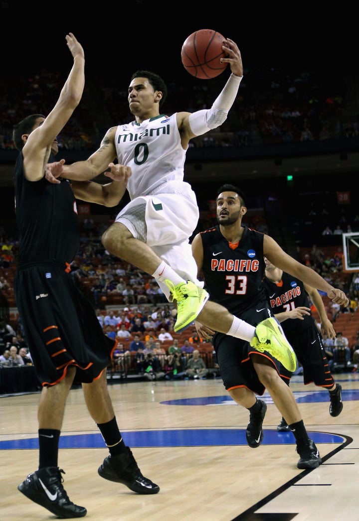 AUSTIN, TX - MARCH 22: Shane Larkin #0 of the Miami Hurricanes drives on Rodrigo De Souza #21 of the Pacific Tigers during t