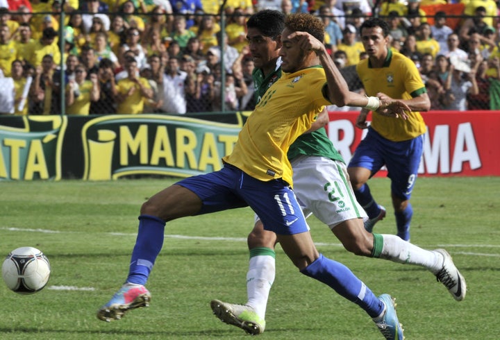 Brazilian national football team player Neymar (front) vies for the ball with Edwar Zenteno of Bolivia during their friendly