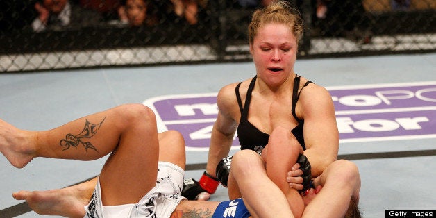 ANAHEIM, CA - FEBRUARY 23: Ronda Rousey (top) attempts to secure an arm bar submission against Liz Carmouche in their women's bantamweight title fight during UFC 157 at Honda Center on February 23, 2013 in Anaheim, California. (Photo by Josh Hedges/Zuffa LLC/Zuffa LLC via Getty Images)