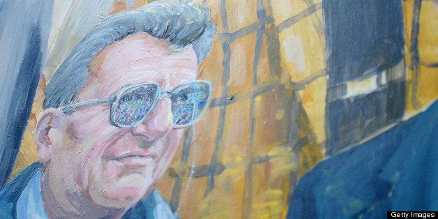 Artist Michael Pilato painted over the halo above Joe Paterno's head on the mural on Hiester Street in downtown State College