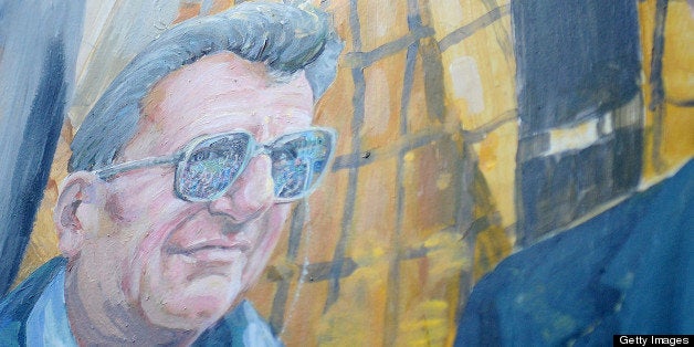 Artist Michael Pilato painted over the halo above Joe Paterno's head on the mural on Hiester Street in downtown State College, Pennsylvania, on Saturday, July 14, 2012. (Abby Drey/Centre Daily Times/MCT via Getty Images)