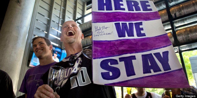Kris Haskins holds his 'Here We Stay' sign as he and other Sacramento Kings fans react to the 22-8 decision in favor of keepi