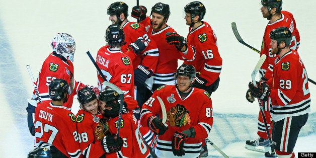 CHICAGO - JUNE 13: Blackhawks celebrate after Andrew Shaw (#65), being hugged by teammate Patrick Kane (#88) at bottom left, tipped the puck past Bruins goalie Tuukka Rask, not pictured, for the game-winning goal. The Boston Bruins visited the Chicago Blackhawks in Game One of the Stanley Cup Finals at the United Center, June 12, 2013, ending in triple overtime, June 13. (Photo by Jim Davis/The Boston Globe via Getty Images)