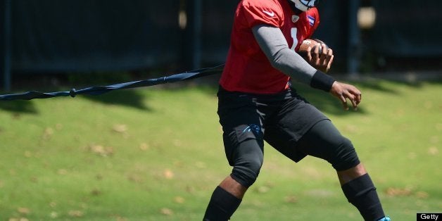 Carolina Panthers quarterback (1) Cam Newton moves around a cone while attached to a bungee rope during mini-camp practice, T