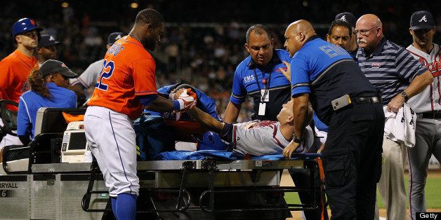 NEW YORK, NY - JULY 24: Eric Young Jr. #22 of the New York Mets shakes Tim Hudson #15 of the Atlanta Braves hand after fracturing his ankle on a play at first base in the eighth inning at Citi Field on July 24, 2013 at Citi Field in the Flushing neighborhood of the Queens borough of New York City. Braves defeated the Mets 8-2. (Photo by Mike Stobe/Getty Images)