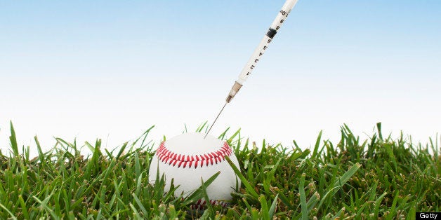 A baseball on grass with a performance enhancing drug syringe.